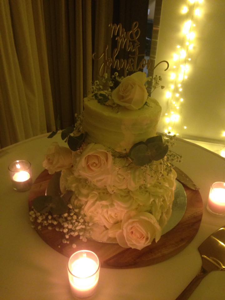 Jess' cake save - wedding cake with fresh flowerd surrounded by tealight candles