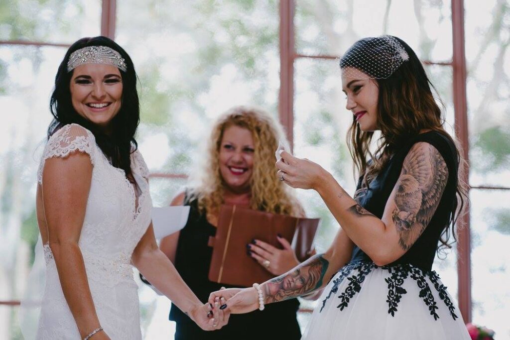 Tash and Teagan - two brides laughing at their wedding with celebrant Lynette Maguire