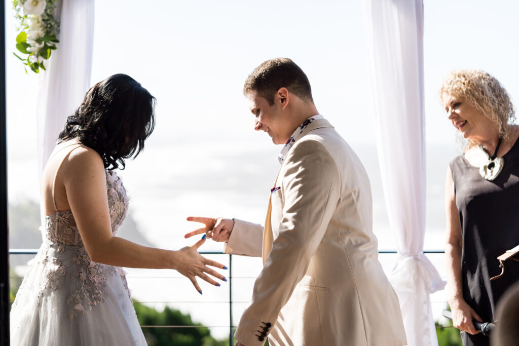 Bride and groom playing game rock paper scissors with Lynette Maguire marriage celebrant