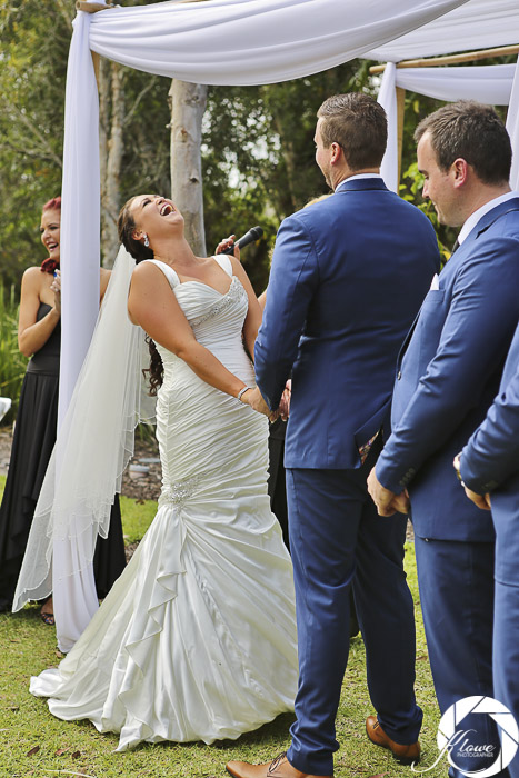 Bride and groom laughing as Lynette Maguire celebrant speaks bride bending backward belly laughing