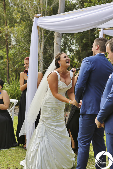 Bride and groom laughing as Lynette Maguire celebrant speaks bride leaning forward