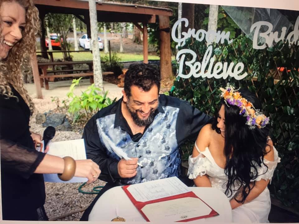 Bride and groom signing legal paperwork  with celebrant Lynette Maguire