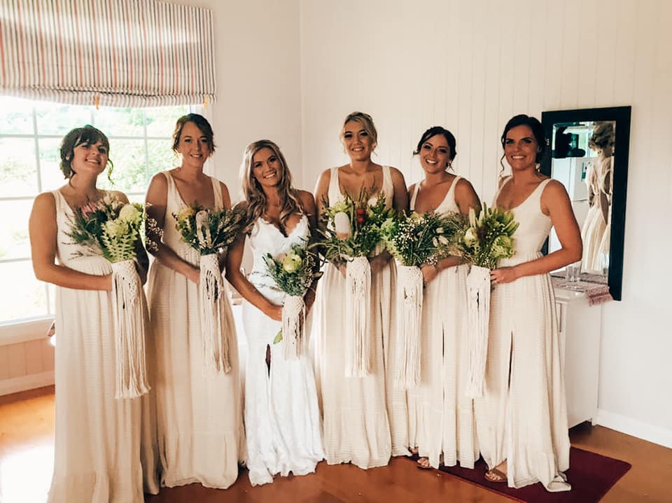 Smiling bride and her five bridesmaids holding Australian native bouquets 