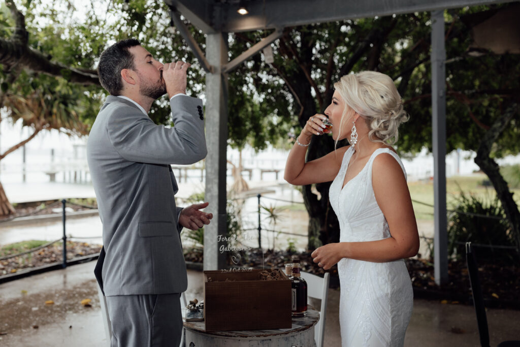 Bride and groom taking shots at the signing table during wedding ceremony